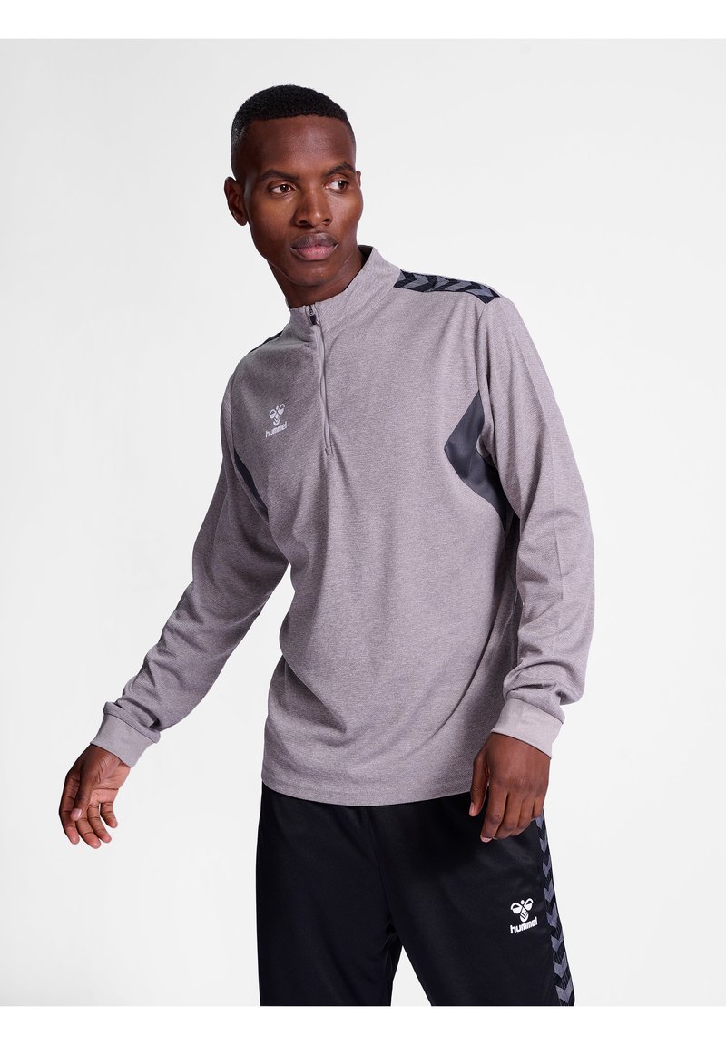 Grijze sportieve pullover met een kwart-rits en lange mouwen, voorzien van donkergrijze zijpanelen en versierd met een logo op de borst.