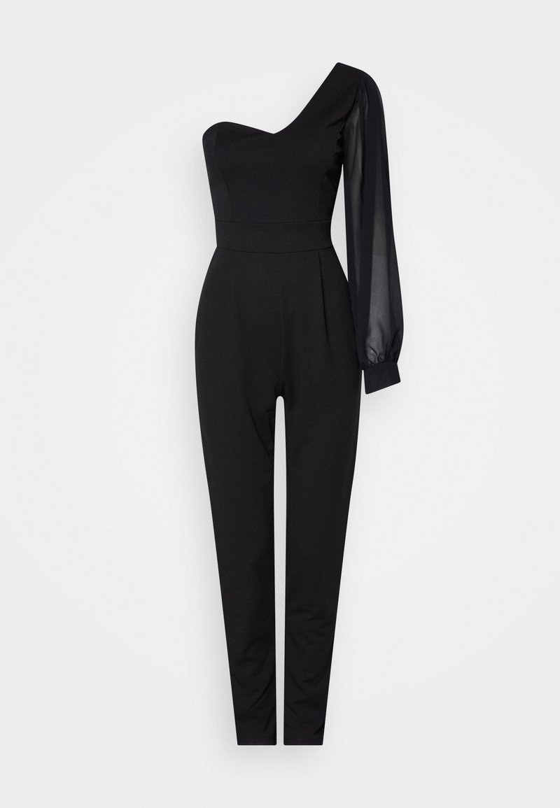 Combinaison noire asymétrique avec taille cintrée, longue manche transparente sur le bras droit et pantalon fuselé sur fond blanc.