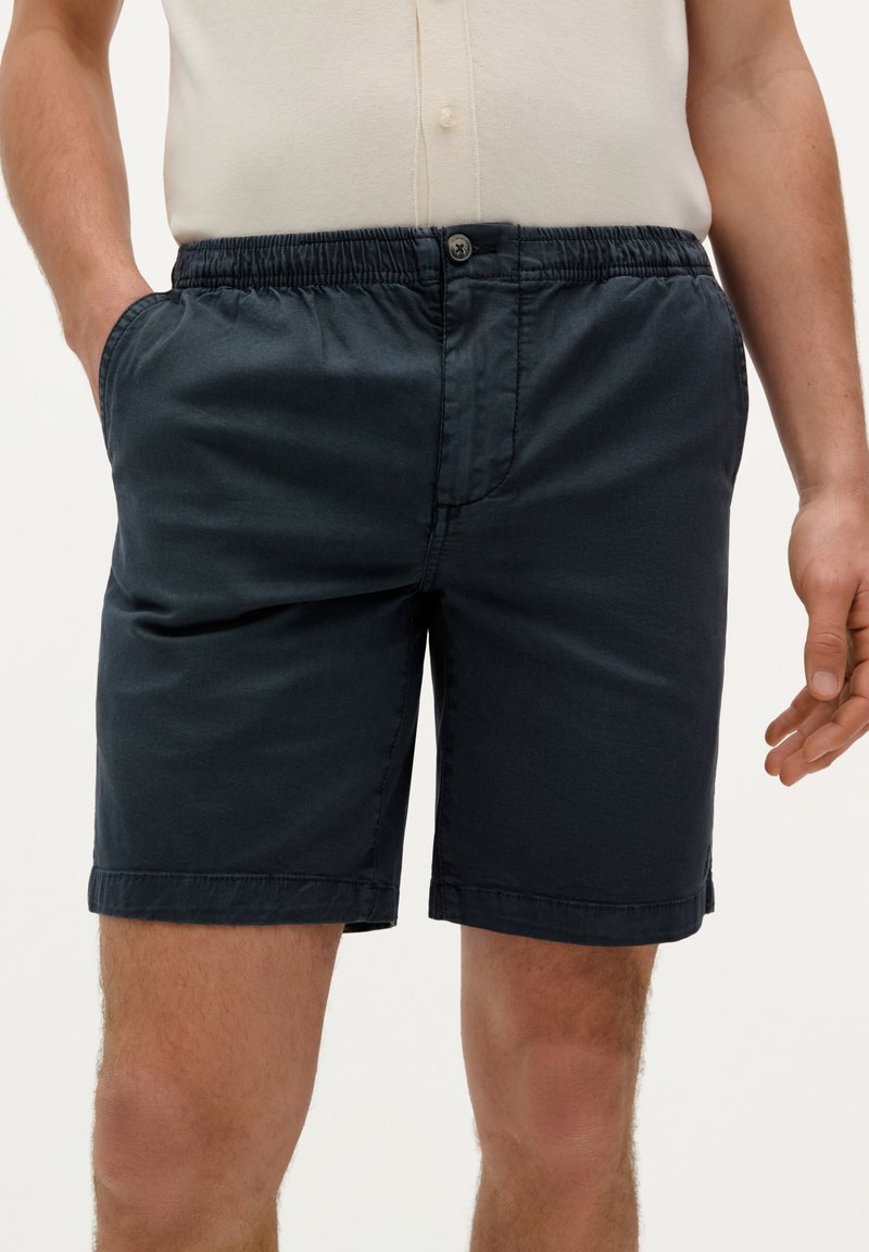 Marineblå shorts lavet af blandet stof, med elastisk talje, sidelommer og en syet kant med lige snit.