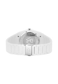 Montre blanche avec un bracelet en silicone et une boucle en acier inoxydable, dotée d'un fond en verre affichant un motif géométrique et un design de logo.