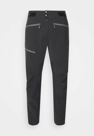 Zwarte outdoor broeken met een slim fit, verstelbare tailleband, reflecterende accenten en meerdere met rits afgesloten zakken. Gemaakt van duurzaam, flexibel materiaal.