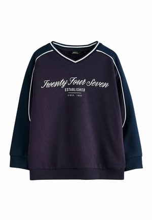 Navy blue V-neck sweatshirt with lighter blue sleeves and white piping, featuring white script text "Twenty Four Seven Established Since 1982" on front.