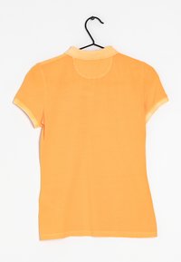 Orange kortärmad pikétröja med krage, tillverkad av ett slätt tyg. Har en rundad bakseam och en rak fåll. Hänger på en svart krok.