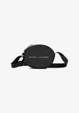 Sac circulaire noir avec une surface texturée ornée de clous en argent. Bandoulière réglable, fermeture éclair et logo "MARC JACOBS" affiché en évidence.