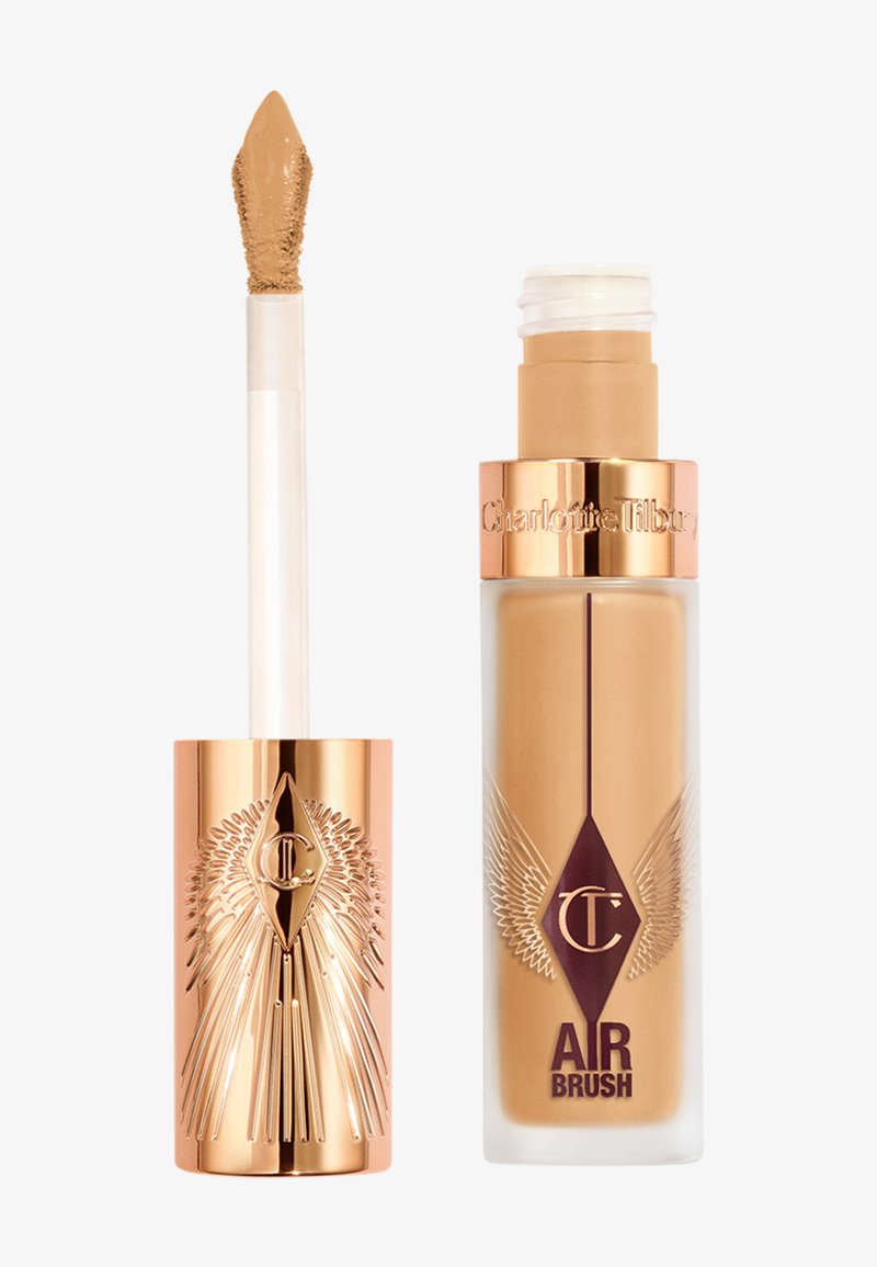 Fond de teint liquide dans une bouteille en verre transparent avec un capuchon doré et un motif d'aile gravé. Comprend un applicateur type embout mousse pour une utilisation facile.