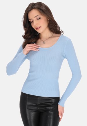 Maglione a manica lunga di colore azzurro chiaro con scollatura rotonda, abbinato a pantaloni neri aderenti. Il tessuto sembra morbido con una leggera elasticità.
