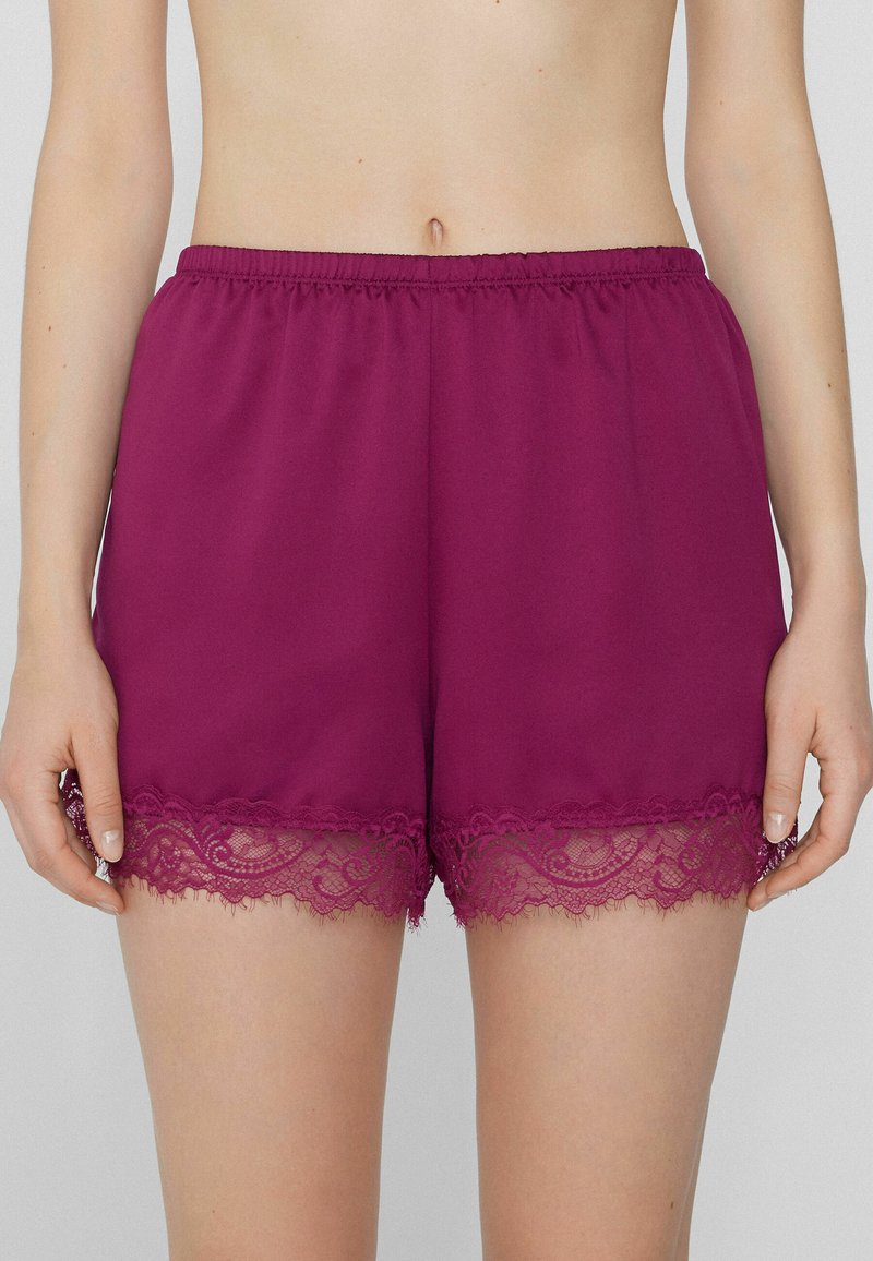 Burgundské šortky vyrobené z hladké látky s krajkovým lemováním na spodním okraji. Elastický pás pro pohodlí. Jednoduchý a elegantní design.