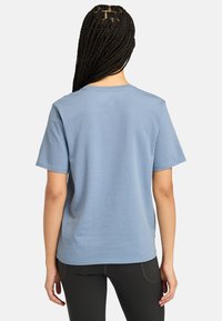 Lyseblå bomulds T-shirt med korte ærmer og rund halsudskæring, der har en ensfarvet kontrast og en afslappet pasform. Bagsiden viser en glat tekstur.