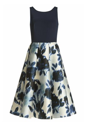 Robe sans manches avec un corsage bleu marine ajusté et une jupe évasée à motif floral bleu et crème, réalisée dans un tissu lisse.