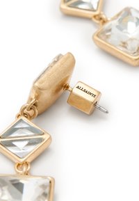Boucles d'oreilles dorées ornées de zircon cubique transparent en forme carrée. Chaque boucle d'oreille dispose d'une fermeture à tige sécurisée. Marquées "ALLSAINTS."
