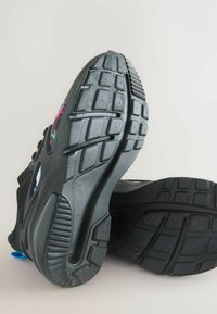 Black athletic shoes with textured rubber soles. Features include multicolored accents on the side and a smooth synthetic upper material.