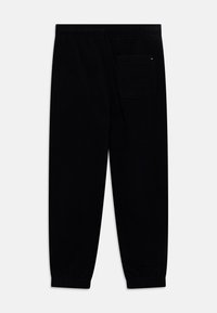 Tommy Hilfiger POLAR UNISEX - Tracksuit bottoms - desert sky