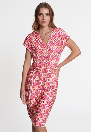 Robe portefeuille en tissu rose avec un motif de chaîne répétitif en crème et orange pâle. Manches courtes, décolleté en V et détail de taille nouée.