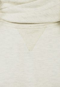 Light beige sweatshirt fabric with a textured, ribbed neckline and a triangular reinforced stitch detail at the collar. Soft and smooth texture.
