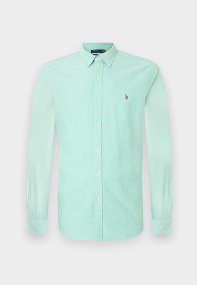Mint green long-sleeve button-up shirt with a collar, featuring small embroidered logo on the left chest and white buttons. Cotton fabric texture.