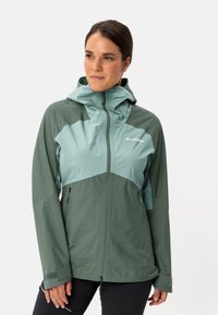 Giacca impermeabile verde e azzurro chiaro con cappuccio. Presenta tasche con zip, un design aderente e una consistenza liscia e leggera.