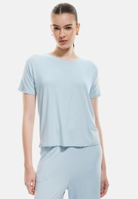 Lichtblauw, T-shirt met korte mouwen van zacht materiaal met een relaxte pasvorm en ronde hals, gecombineerd met bijpassende lichtblauwe broek.