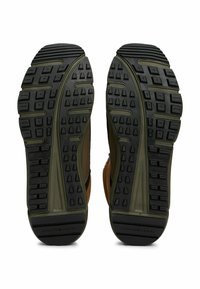 Scarpe da hiking in suede marrone e tessuto con suole in gomma nera. Il battistrada presenta tasselli multidirezionali per una migliore trazione. Accenti laterali in verde scuro.