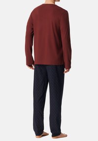Pánský set domácího oblečení s vínově červenou dlouhým rukávem a modrými kalhotami s jemným červeným vzorem, vyrobený z měkké a prodyšné látky.