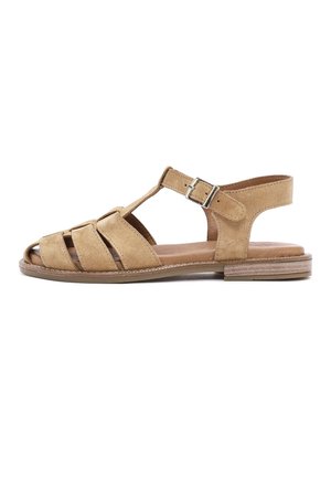 Tan suede flat sandal with open toe, T-strap, three front straps, adjustable buckle, and low stacked heel on white background.