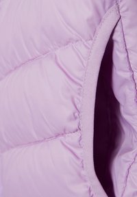 Lavendel puffjacka sektion med kviltat, glänsande nylon tyg. Har en slät yta, avslutade kanter och ett inre tygfoder.