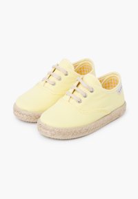 Baskets en toile jaune avec des orteils ronds, des lacets beige et des semelles en jute de style espadrille. L'intérieur présente un motif à carreaux jaune.