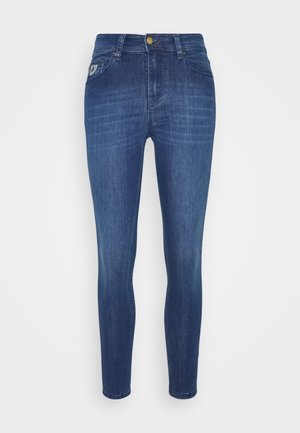 Slim-fit blauwe denim jeans met vijf zakken, knoop- en ritssluiting, en subtiele vervaging op de voorkant van de dijen.