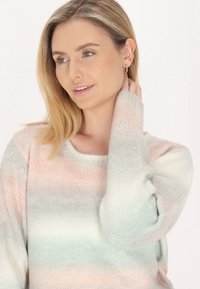 Pulover usor, tricotat, cu un gradient de culori pastelate roz, albastru și alb; dispune de un guler rotund și mâneci lungi.