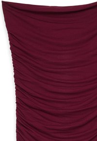 Burdeauxi värvi veniv kangas, vertikaalse kurrutamisega, sile tekstuur ja volditud disain, näidates sügavust ja mõõtmeid.