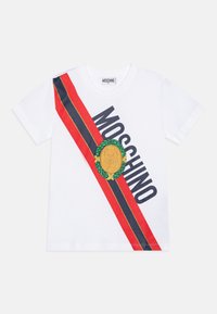 White t-shirt featuring a red and navy diagonal stripe, "MOSCHINO" text, and a gold bear emblem surrounded by green laurel leaves.