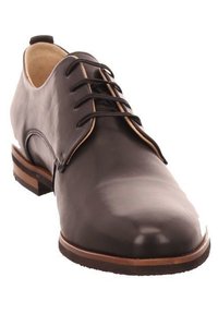 Black leather dress shoe with a rounded toe, six eyelets, brown accent stitching, and a low stacked heel. Smooth texture, polished finish.
