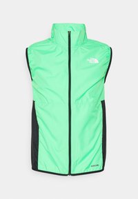 Chaleco sin mangas de color verde brillante con cuello alto, paneles laterales negros, cremallera frontal y logo de "The North Face" en el pecho. Material resistente al viento.