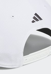 Gorra de béisbol blanca con superficie texturizada, que presenta un logo bordado en negro y una correa ajustable blanca en la parte trasera.