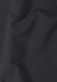 Tissu noir en tricot avec des plis doux visibles et une texture fine.