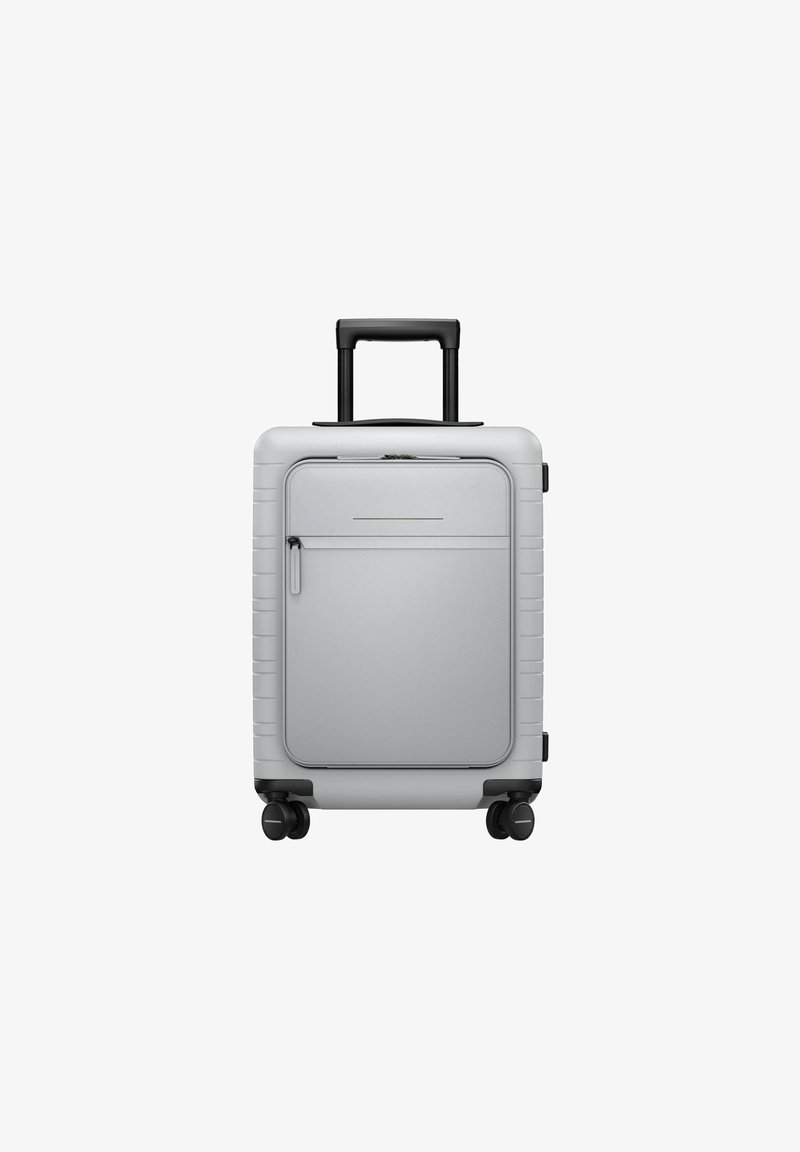 Silver hard-shell suitcase with retractable black handle, smooth texture, front zippered pocket, and four wheels for mobility.