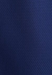 Marineblauwe stof met een gestructureerd visgraatpatroon, geweven met een gladde afwerking. Geschikt voor meubelbekleding of kledingtoepassingen.