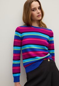 Maglione a righe con colori vivaci: rosa, blu, verde e nero. Realizzato in materiale morbido, con maniche lunghe e scollo rotondo.