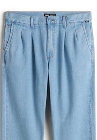 Pantalones de mezclilla azul claro con frente plano, pliegues y bolsillos laterales. Cuenta con un cierre de botón y una etiqueta con el logo en la cintura.