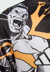 Czarna, biała i pomarańczowa koszulka sportowa z grafiką muskularnej postaci o głośnej mimice. Wykonana z gładkiego materiału.