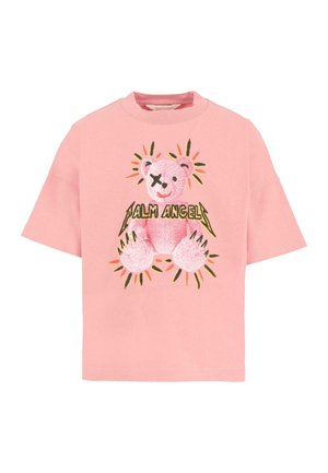 Roze T-shirt met korte mouwen met een afbeelding van een roze teddybeer, waarvan één oog doorgestreept is, omringd door kleurrijke stralen en de tekst "Palm Angels".