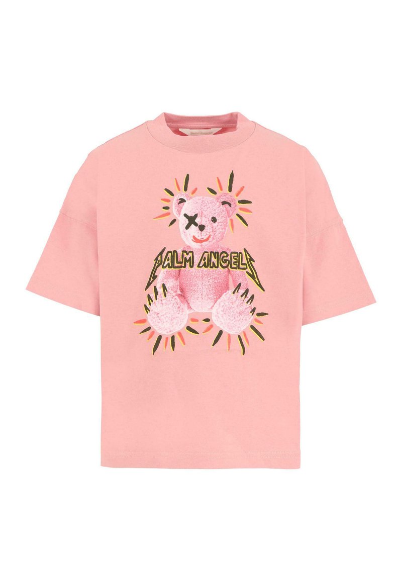 Różowy bawełniany T-shirt z krótkimi rękawami, z grafiką misia w jasnoróżowym kolorze z czarnymi akcentami i żółtymi detalami promieni słonecznych. Tekst brzmi „Palm Angels.”