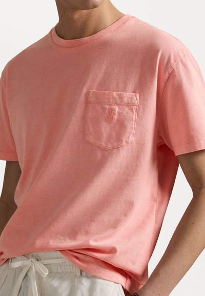 Cotton t-shirt, light coral color, crew neck, short sleeves, featuring a pocket on the left chest with a logo. Smooth texture.