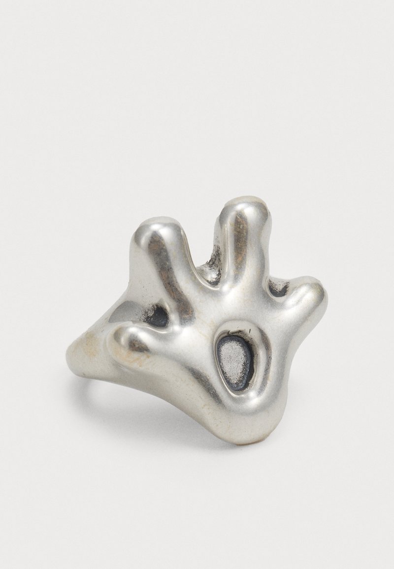 Silberring mit organischem Design, das eine strukturierte Oberfläche und abstrakte fingerähnliche Formen zeigt. Enthält einen markanten dunklen, kreisförmigen Akzent.