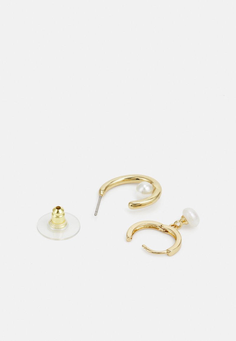 Goldene Creolen mit glatter Oberfläche, die eine weiße Perle als Akzent und eine klare Rückseite besitzen. Das Design ist minimalistisch und modern.