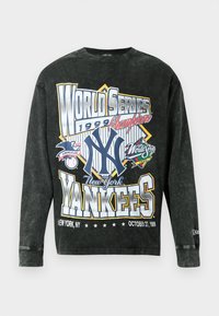 Juodas ilgomis rankovėmis t-shirt su vintage 1999 metų Pasaulio serijos grafika, turinti ryškų, daugiaspalvį tekstą ir logotipus, pagaminta iš švelnaus medvilnės audinio.