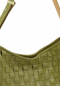 Borsa a tracolla in pelle verde intrecciata, con una forma morbida e curvilinea dai bordi lisci. Presenta una sola tracolla regolabile e dettagli di cucitura discreti.