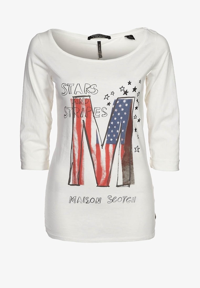 Valkoinen pitkähiha T-paita, jossa on graafinen printti kirjaimesta "M" punaisena, valkoisena ja sinisenä, sekä teksti "STARS AND STRIPES" mustalla.