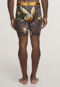 Czarne bokserki z złotym paskiem w talii oraz zabawnym wzorem złotych królików i czerwonych akcentów na teksturowanym falistym tle.