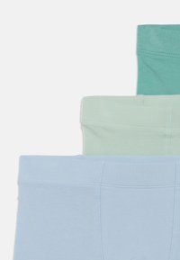 Tri páry mäkkého látkového spodného prádla v svetlomodrej, mäty zelenej a tyrkysovej farbe, s bezšvovými pásmi a hladkou textúrou.