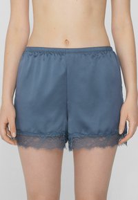 Satin pyjamashorts in een leisteenblauwe kleur, met een kanten rand aan de zoom, een elastische tailleband en een gladde textuur.